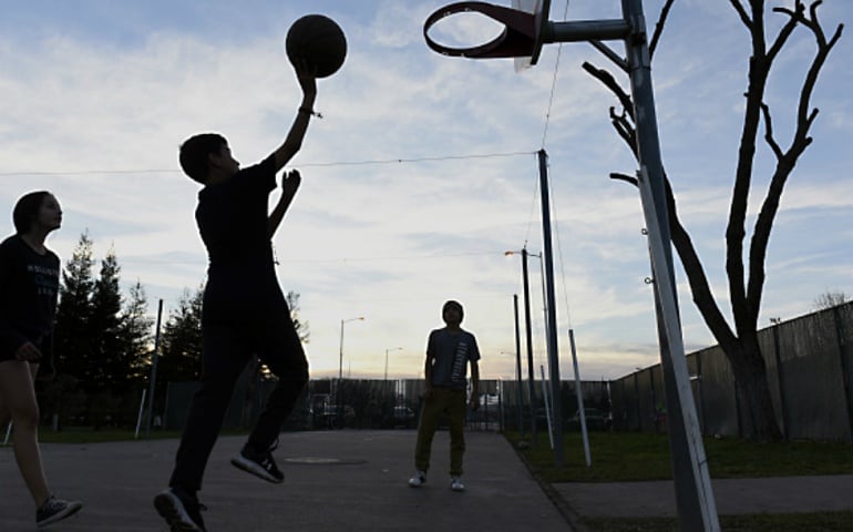 Un grupo de niños juega al baloncesto en Chico, California.