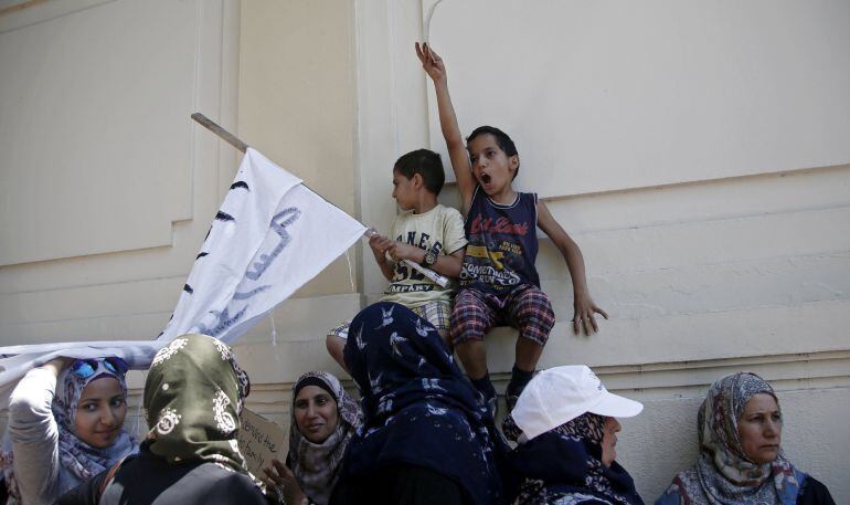 Varios refugiados sirios protestan en la entrada de la Embajada alemana en Atenas (Grecia) contra la decisión de Alemania de limitar el número de reunificaciones familiares.