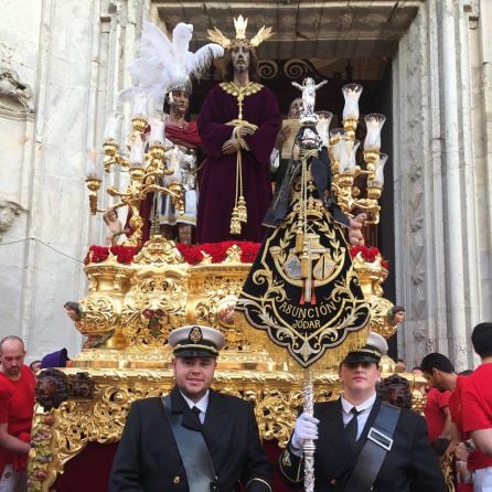 Dos miembros de la Banda de la Asunción muestran la Bandera de la banda ante el paso ante el paso de la Sentencia de Cádiz