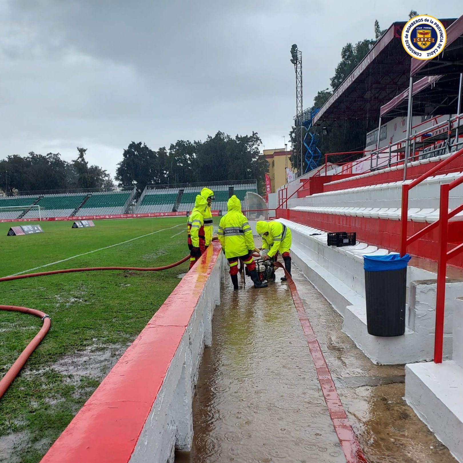 Los bomberos de Chiclana achicando agua durante todo el día para que se pudiera disputar el encuentro