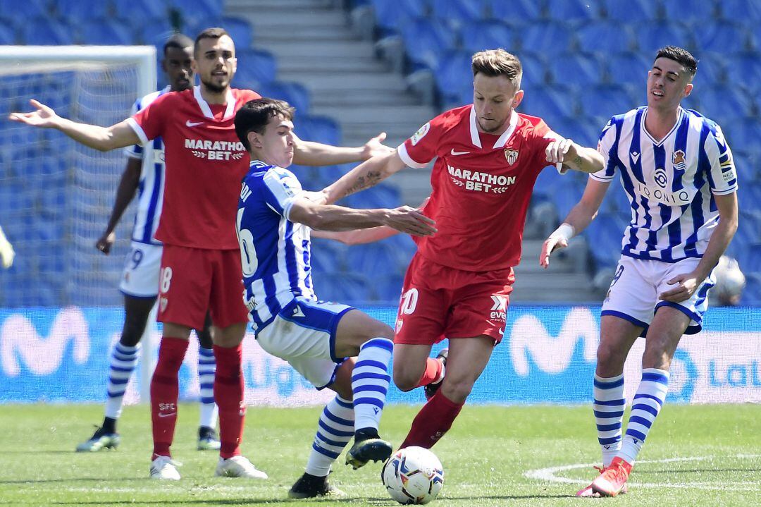Zubimendi intenta cortar un balón a Rakitic anbte la mirada de Jordan y Carlos Fernández