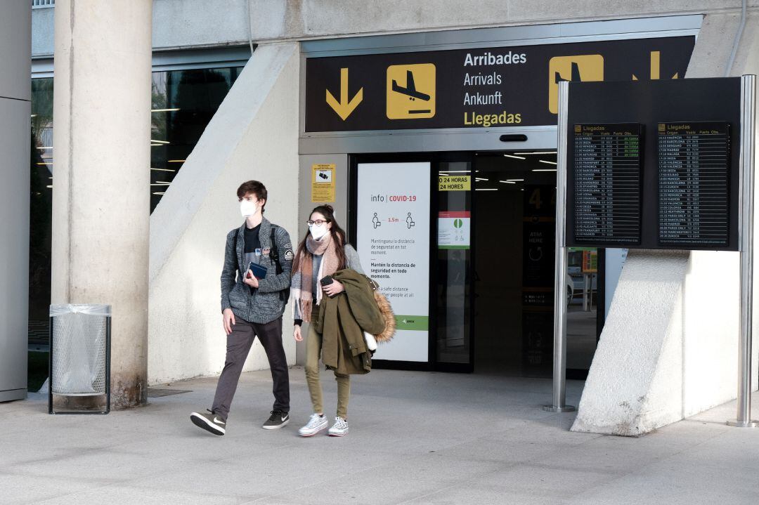 Dos viajeros salen del aeropuerto de Palma de Mallorca.