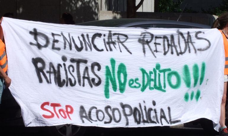 Pancarta de un acto de Brigadas Vecinales contra las redadas racistas