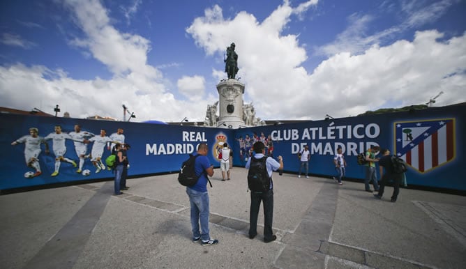 Unos turistas fotografían un cartel alusivo a la final de la Liga de Campeones, exhibido en la Plaza del Comercio de Lisboa