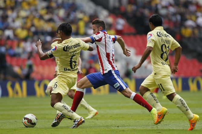 Saúl pugna por un balón ante el América