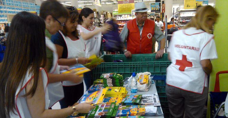 Voluntarios de Cruz Roja recogiendo material escolar