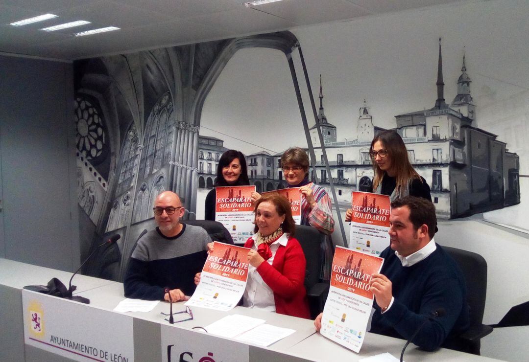 Mimebros de las distintas organizaciones posan junto al cartel de la iniciativa