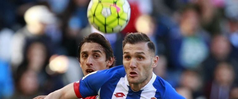 El delantero del Deportivo Lucas Pérez se lleva un balón ante el uruguayo Damián Suárez, del Getafe.