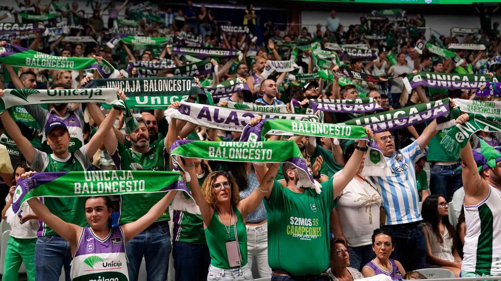 Aficionados del Unicaja levantan sus bufandas en un partido en el Carpena