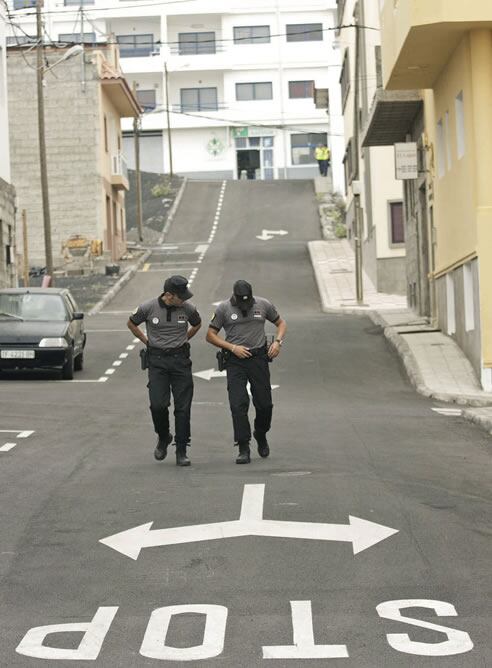 Dos agentes de la Policía Canaria recorren una calle vacía del pueblo costero de La Restinga, en la isla canaria de El Hierro, desalojado a causa de la erupción volcánica que azota su costa.