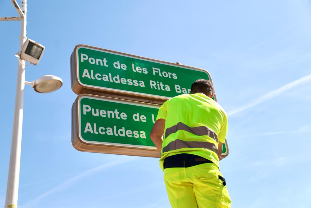 Operarios instalando la placa con el nuevo nombre del puente de las Flores - Alcaldesa Rita Barberá