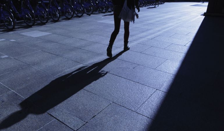 Una mujer camina de noche / GETTY IMAGES