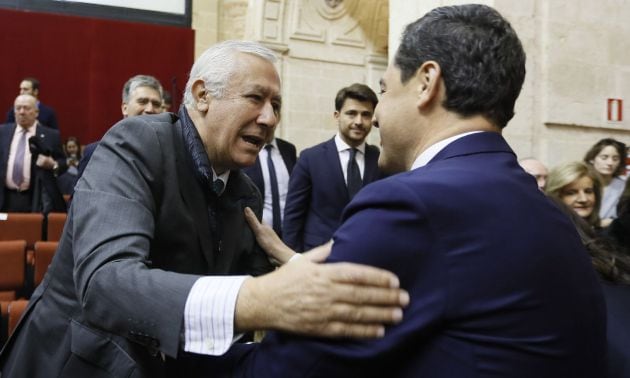 El senador y presidente de honor del PP-Andalucia, Javier Arenas (c-i), saluda al líder del PP-A, Juanma Moreno (d), en el Parlamento andaluz