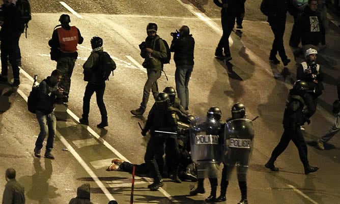 Varios agentes antidisturbios detienen a un joven en las inmediaciones de la Plaza de Colón tras la manifestación del 22-M