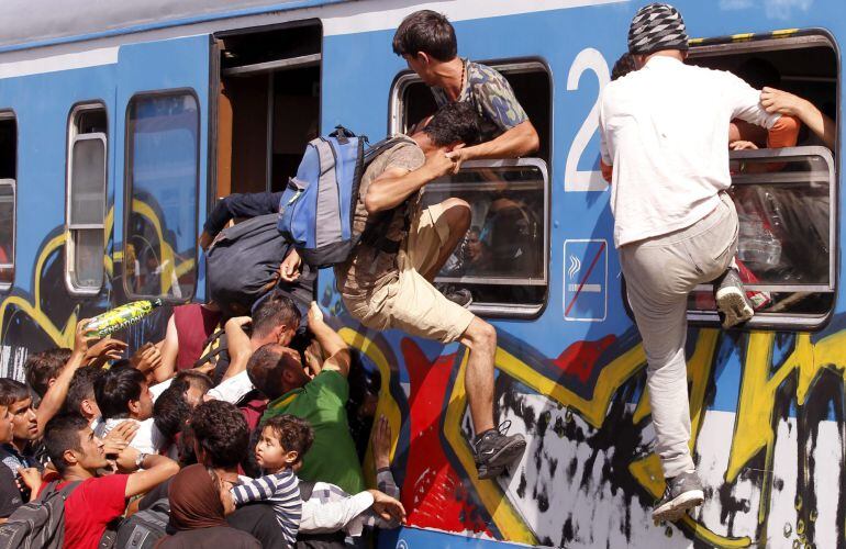 Refugiados se empujan entre sí para subir a bordo de un tren rumbo a Zagreb en la estación de Beli Manastir (Croacia).