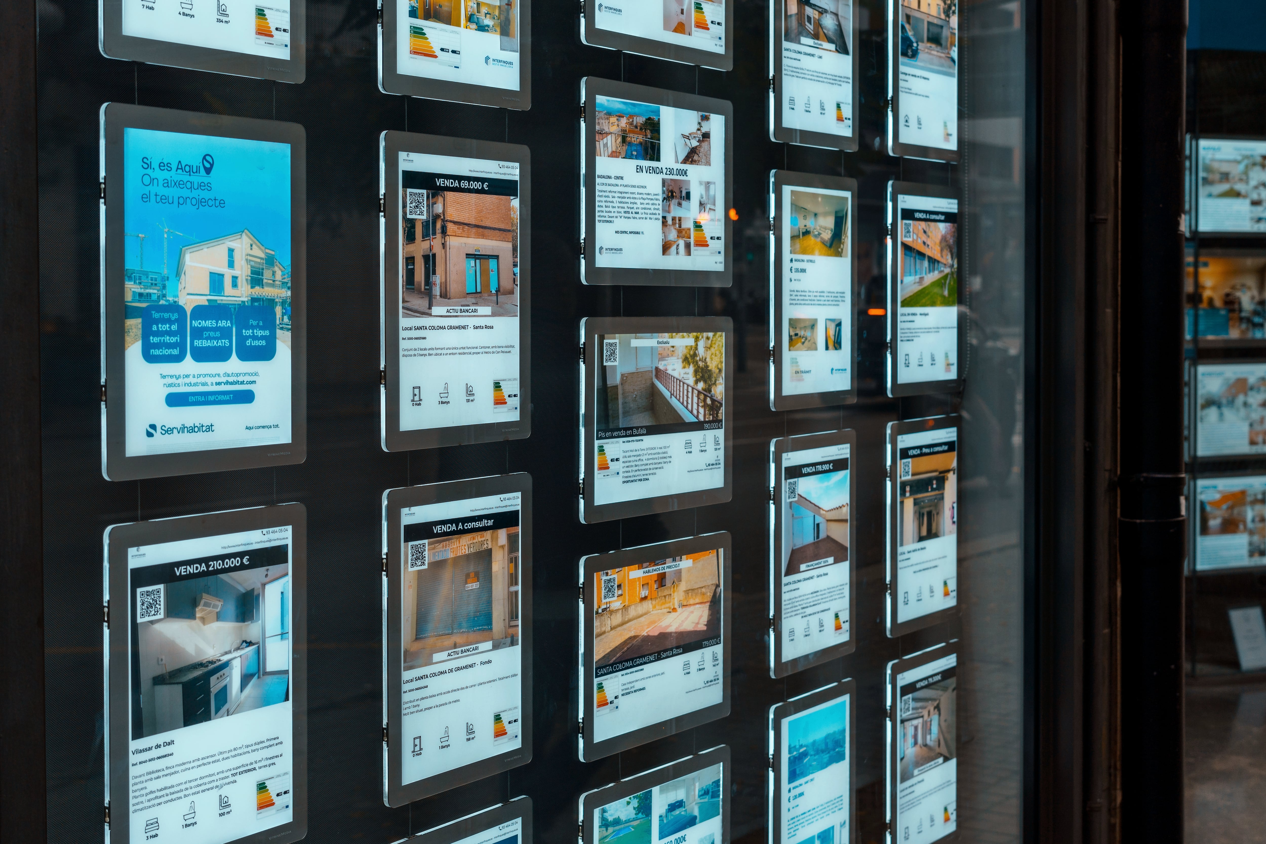 Escaparate de una agencia inmobiliaria con anuncios de pisos en venta o alquiler