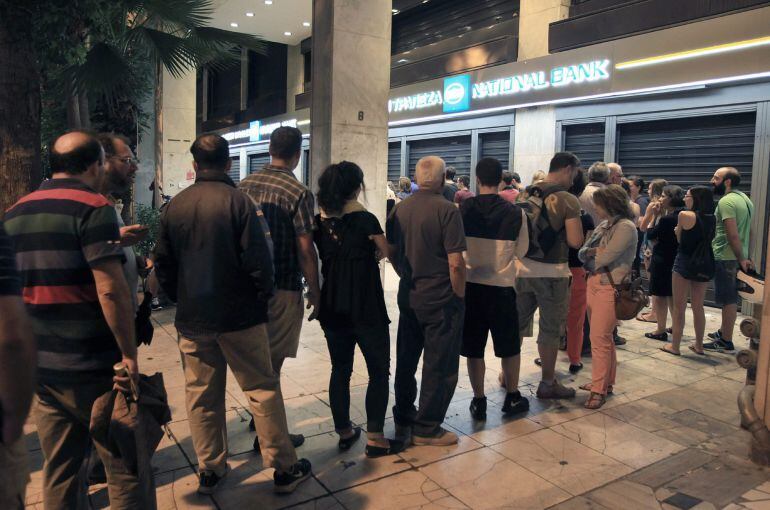 ARE23. Athens (Greece), 28/06/2015.- People queue up to withdraw money from an ATM outside a branch of Greece&#039;s National Bank in Athens, Greece, 28 June 2015. Greece is imposing capital controls and ordering the closure of banks, Prime Minister Alexis Tsi