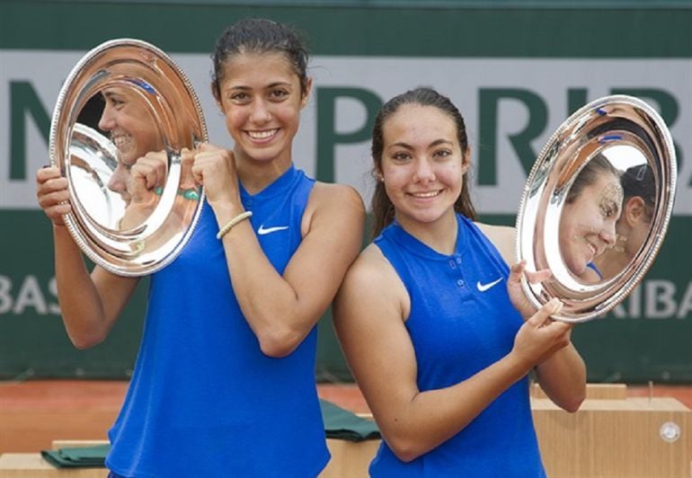 Paula Arias y Olga Danilovic sonrientes, tras recoger su trofeo de campeonas en dobles, del Roland Garros Junior