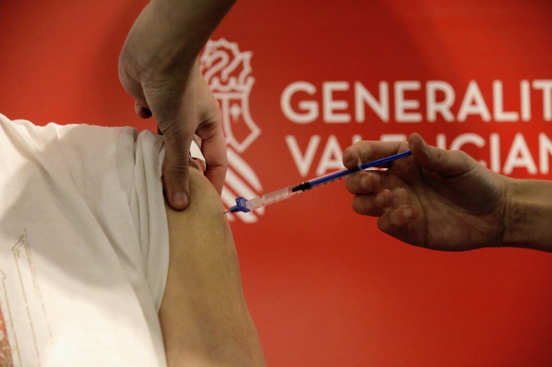 Una sanitaria vacuna a un hombre en el primer día de la vacunación masiva en Alicante