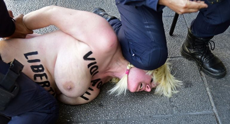 Dos policías retienen a la activista de Femen. 