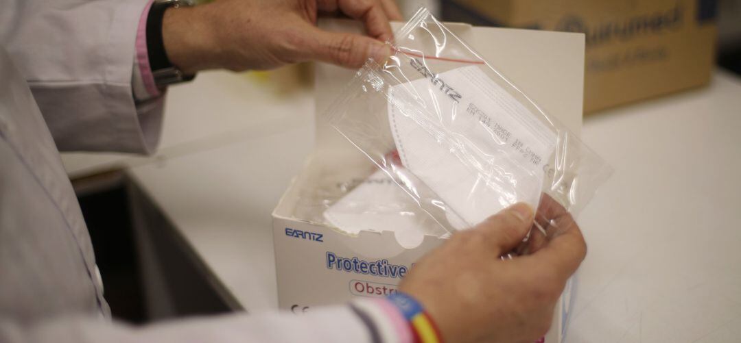 Un farmacéutico muestra mascarillas a la venta