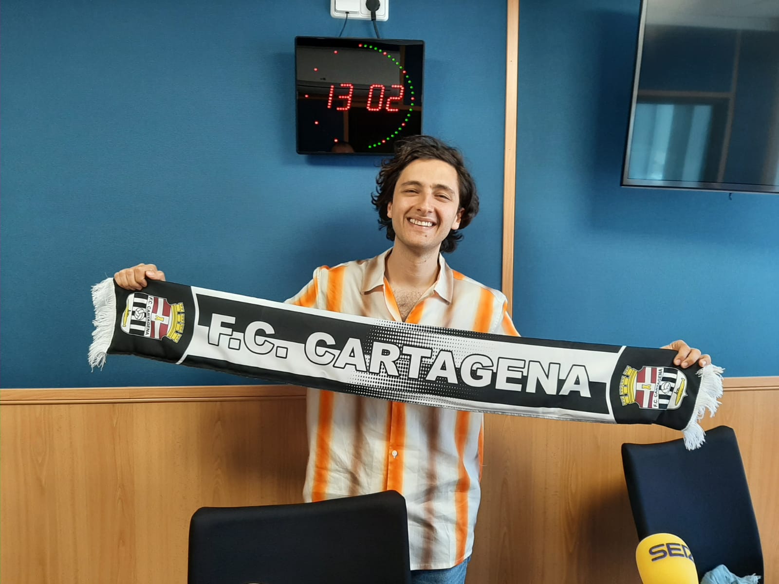 Antonio García, cantante de Arde Bogotá, en Radio Cartagena con una bufanda del Efesé