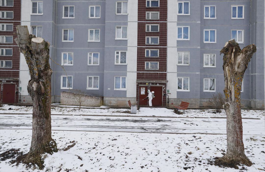 Un especialista del Servicio Veterinario de la región de Leningrado con traje protector de materiales peligrosos rocía desinfectante en un área residencial en Izvora, en las afueras de San Petersburgo, Rusia. 