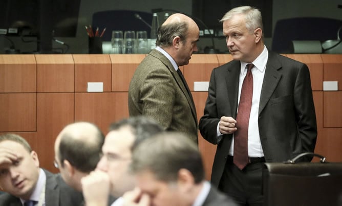 El vicepresidente de la Comisión Europea Olli Rehn conversa con el ministro español de Economía, Luis de Guindos (c), antes del inicio de la reunión de ministros de Finanzas de la UE en Bruselas