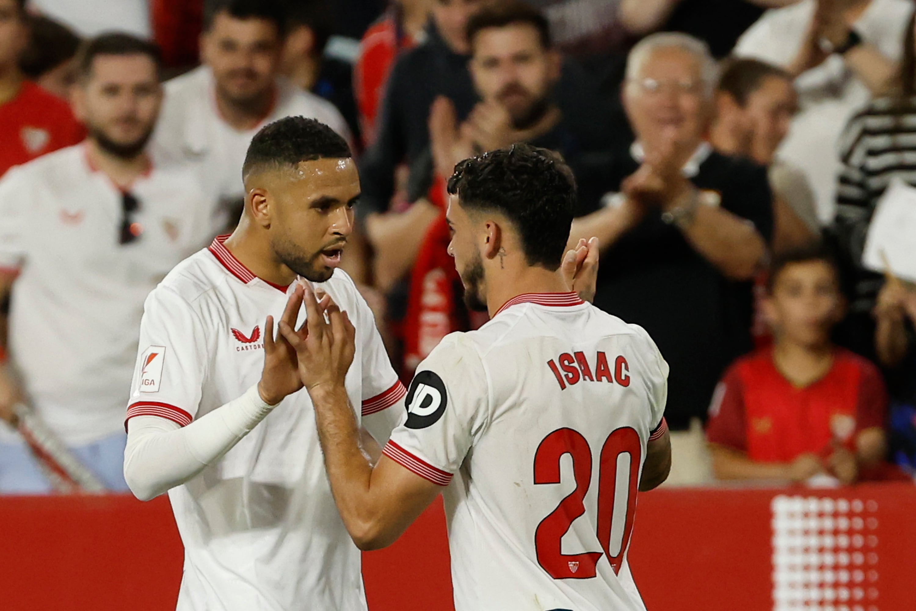 SEVILLA, 22/04/2024.- El delantero del Sevilla Isaac Romero (d) celebra con Youssef En-Nesyri (i) tras marcar el 2-0 ante el Mallorca, durante el partido de la jornada 32 de LaLiga que Sevilla FC y RCD Mallorca juegan este lunes en el estadio Sánchez-Pizjuán de Sevilla. EFE/ Julio Muñoz
