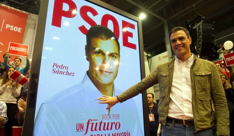 El candidato socialista, Pedro Sánchez, posa junto a su cartel electoral.