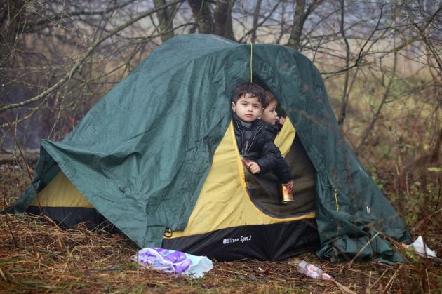 Dos niños migrantes salen de la tienda de campaña donde pasan las noches en la región de Grodno