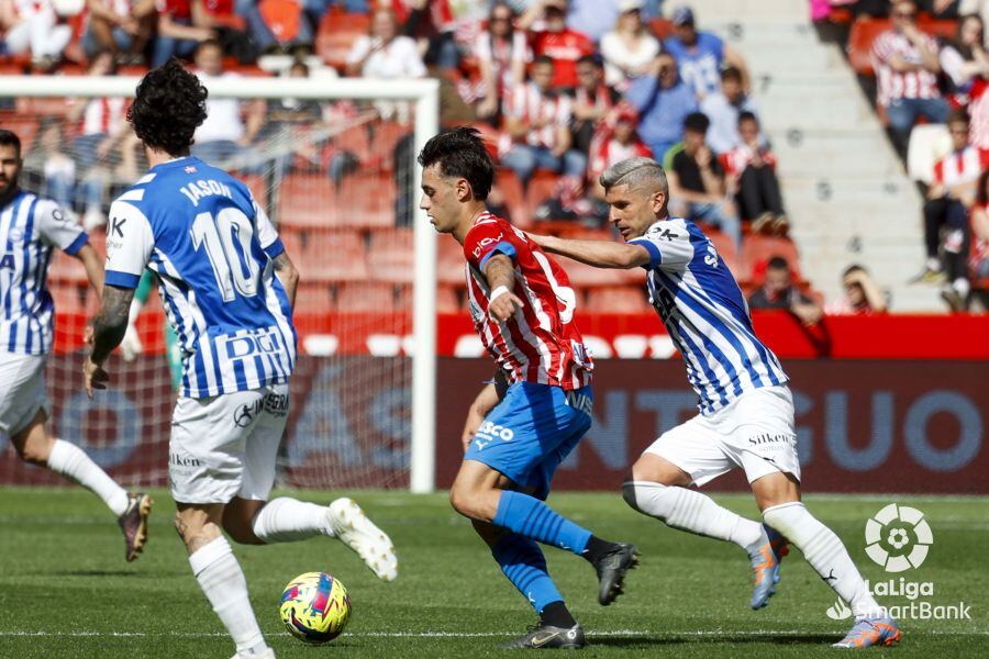 Pedro Díaz se lleva el balón, presionado por Salva Sevilla, durante el Sporting - Alavés.