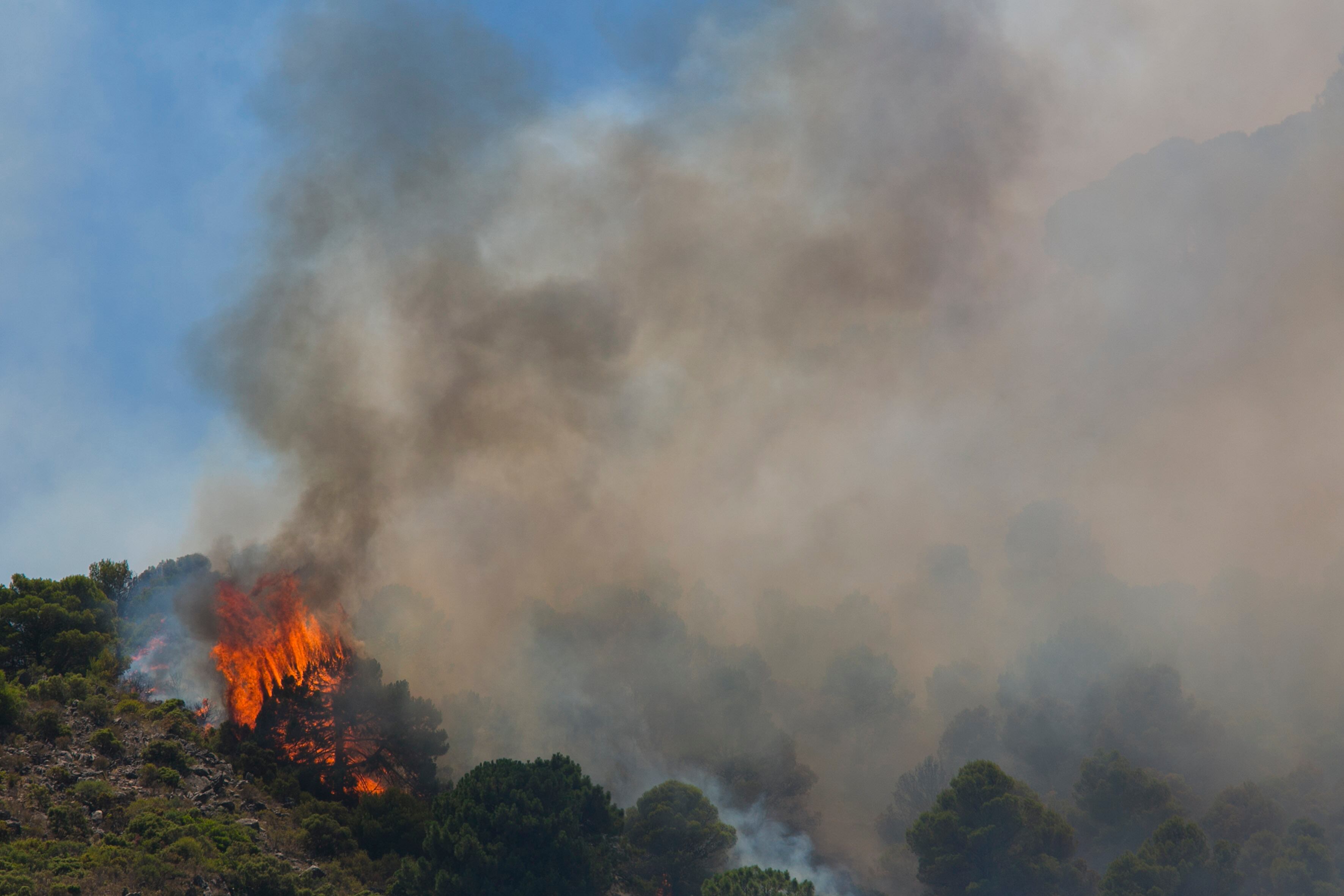 ALHAURÍN DE LA TORRE (MÁLAGA) 16/07/2022.- Un helicóptero del servicio de bomberos trabaja en el incendio declarado en la sierra de Mijas, Málaga, este sábado. EFE/Álvaro Cabrera
