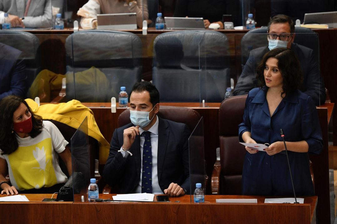 La presidenta regional, Isabel Díaz Ayuso (d), junto al vicepresidente, Ignacio Aguado (c), y la consejera de Presidencia, María Eugenia Carballedo (i), durante su intervención en el pleno de la Asamblea de Madrid 