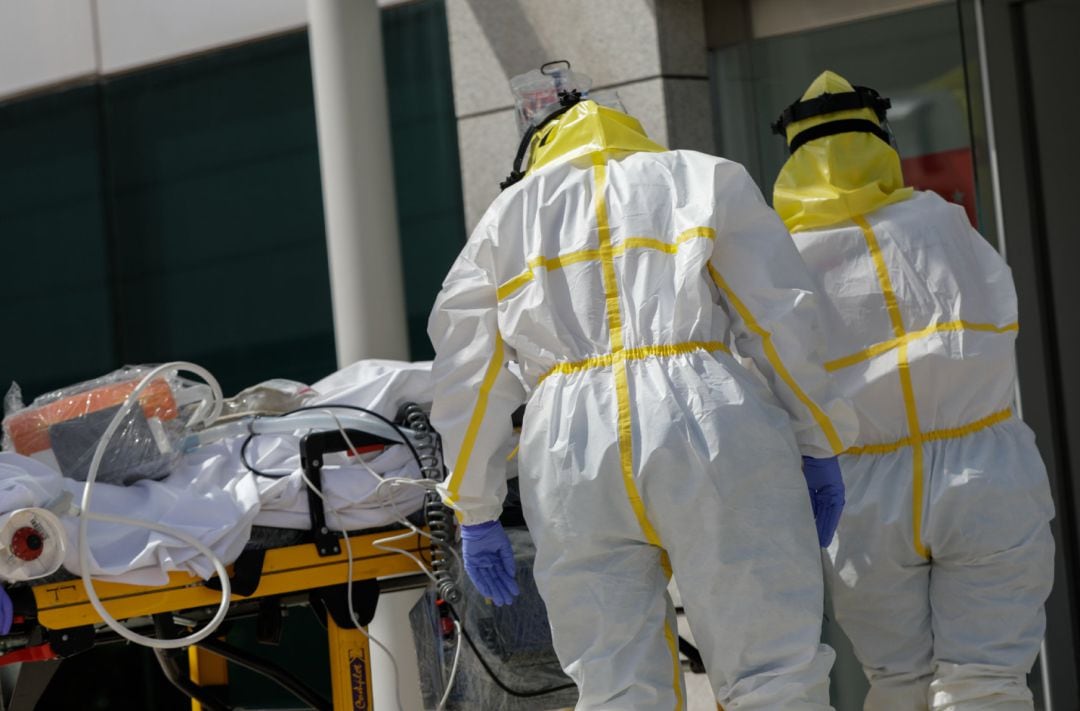 Varios sanitarios trasladan a un paciente desde el interior de una unidad móvil