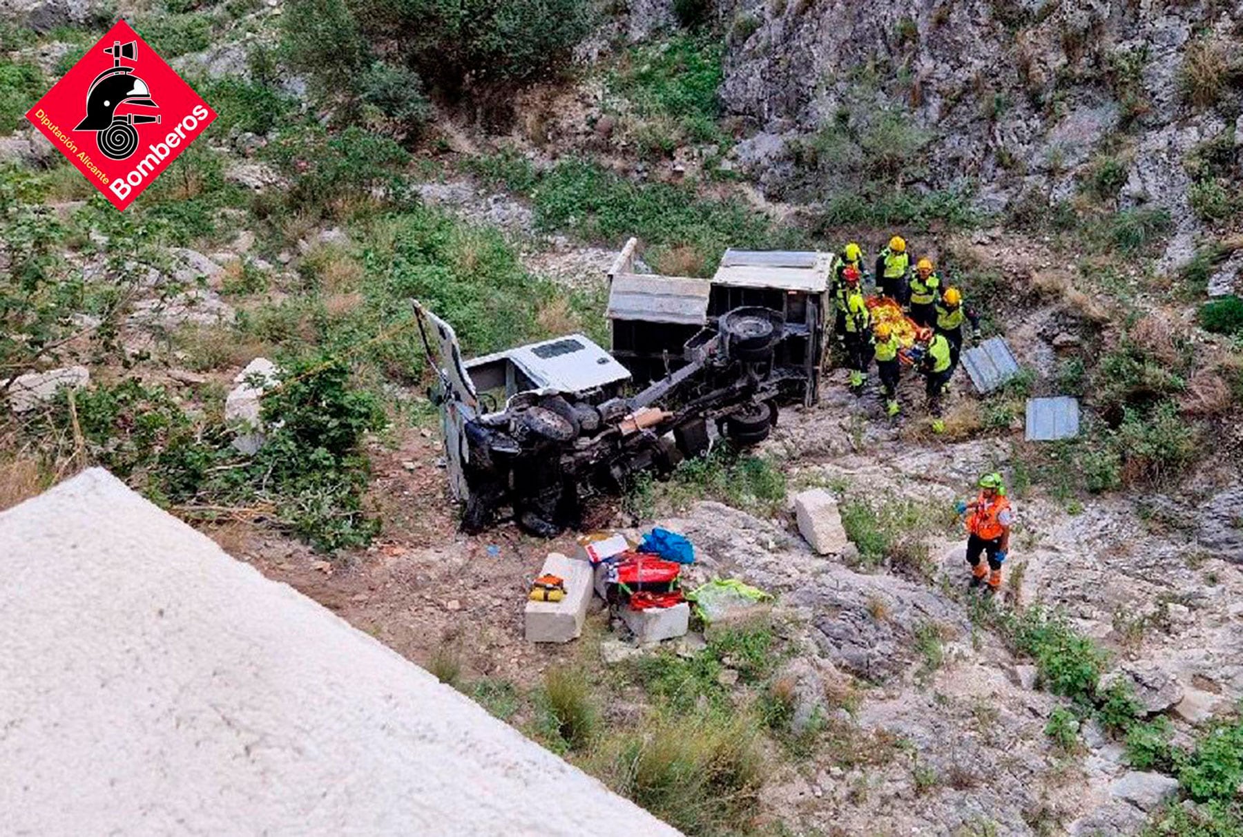 Imagen del camión accidentado y de la actuación de los bomberos para rescatar a los dos heridos