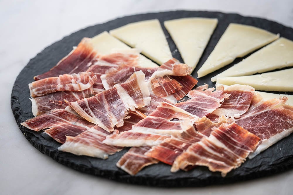 Un plato con jamón y queso