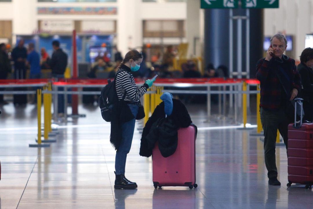 Una turista con mascarilla y guantes en el aeropuerto 