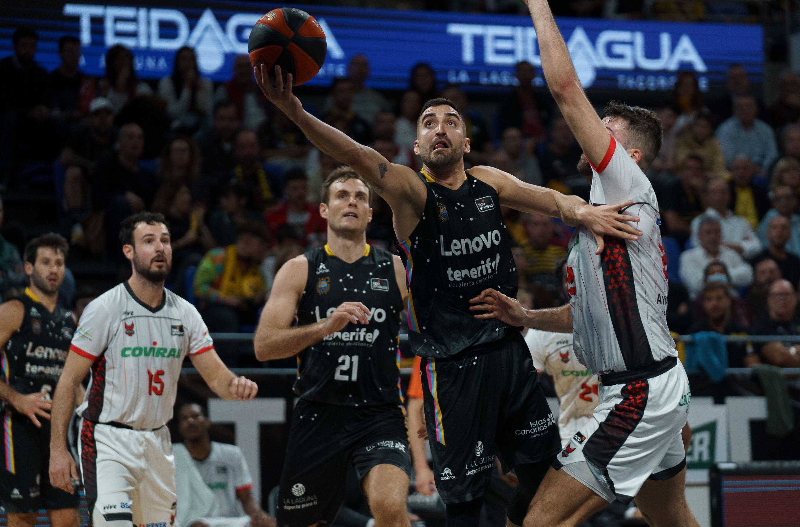 LA LAGUNA (TENERIFE), 29/12/2022.- El base del Lenovo Tenerife Jaime Fernández (2d) lanza a canasta ante un rival del Covirán Granada durante el partido de baloncesto de la liga ACB celebrado este jueves en el pabellón Santiago Martín de La Laguna (Tenerife) EFE/Ramón de la Rocha