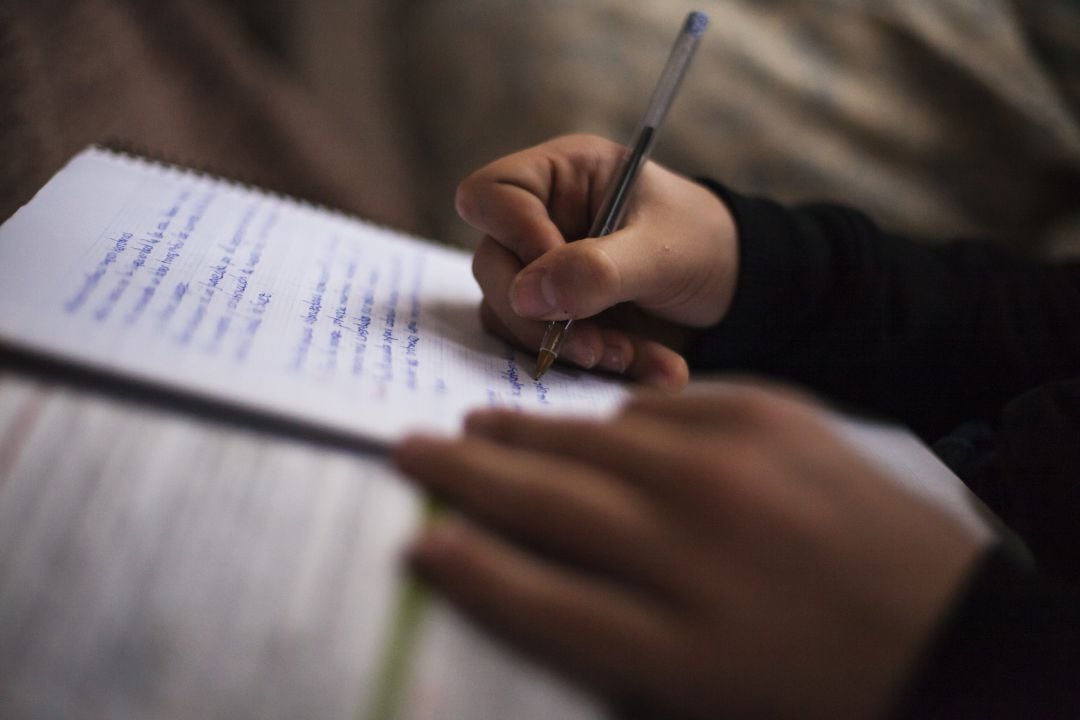 Un alumno toma notas en su cuaderno.