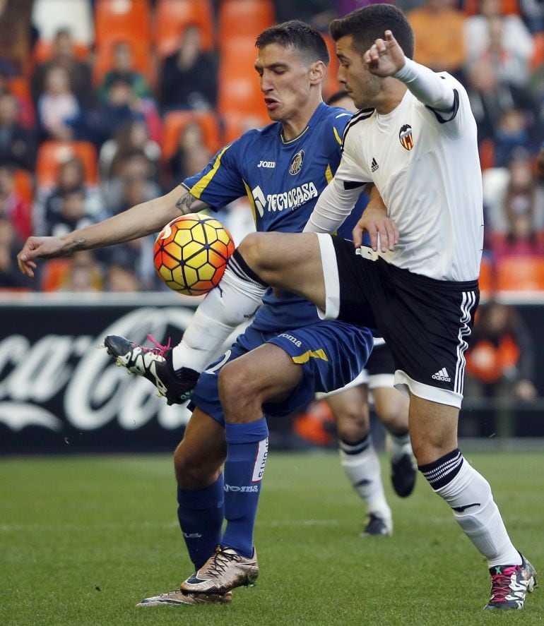 El defensa del Valencia José Luis Gayá (d) pelea un balón con el delantero serbio del Getafe Stefan Scepovic durante el partido de la decimosexta jornada de liga en Primera División que se disputa esta tarde en el estadio de Mestalla. EFE-Juan Carlos Cárdenas