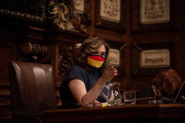 La alcaldesa de Barcelona, Ada Colau, con una mascarilla de la bandera republicana, interviene en el Pleno del Ayuntamiento, el último que se celebra antes del parón estival y el primero que tiene lugar con el retrato del rey colocado de nuevo en la sala 