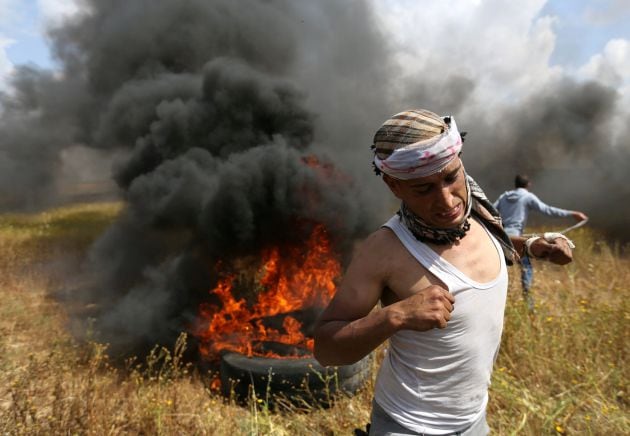 Un palestino corre durante los enfrentamientos con soldados de Israel