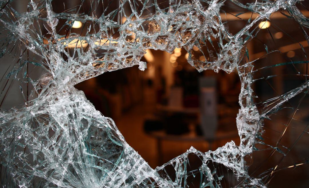 Vista de una tienda a través de su cristalera rota tras una noche de protestas, en Madrid.