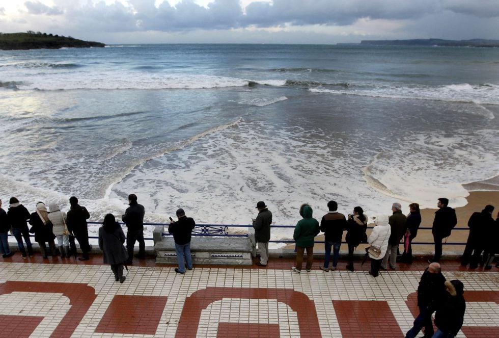 Vecinos de Santander observan el estado de la mar desde el paseo marítimo de la localidad destruido el pasado invierno, durante el temporal marítimo que mantiene hoy a Cantabria en alerta naranja por fenómenos marítimos adversos, aunque no se han producid