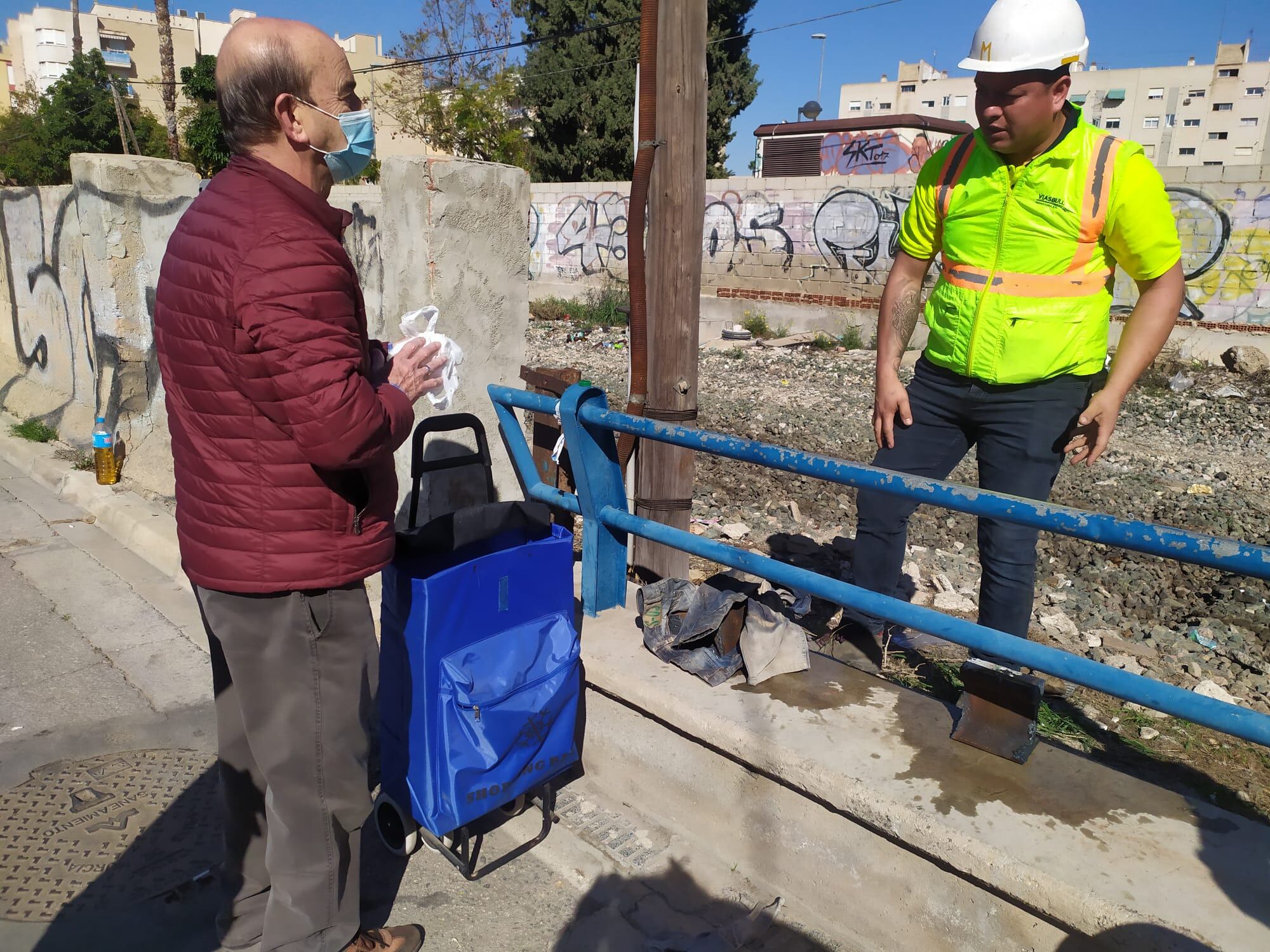 Un operario de ADIF le entrega a Pedro Arques, miembro de la Plataforma Prosoterramiento, dos trozos de la vía que están retirando en Barriomar (Murcia)