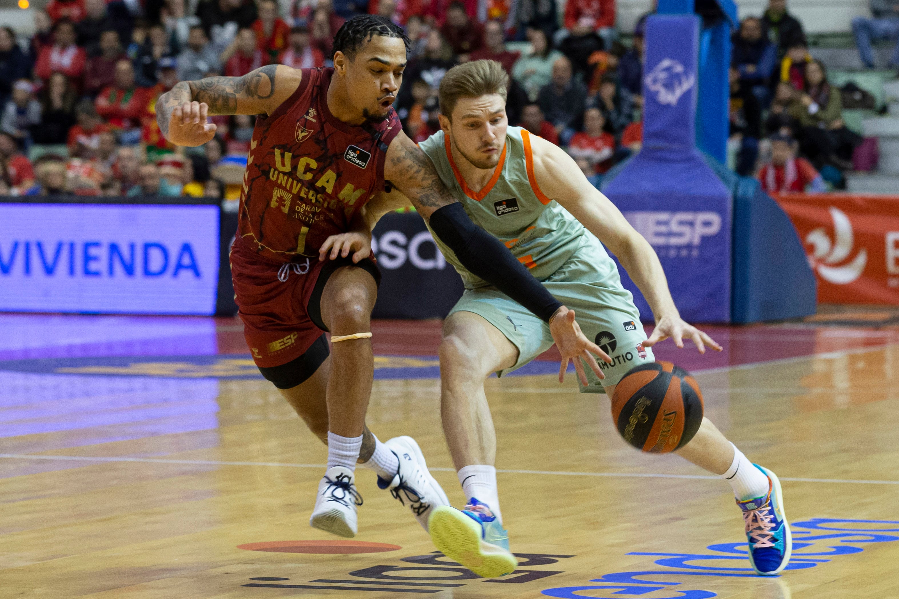 El base letón del Baskonia Arturs Kurucs (d) controla el balón ante la oposición del base estadounidense de UCAM Murcia Jordan Davis. EFE/Marcial Guillén