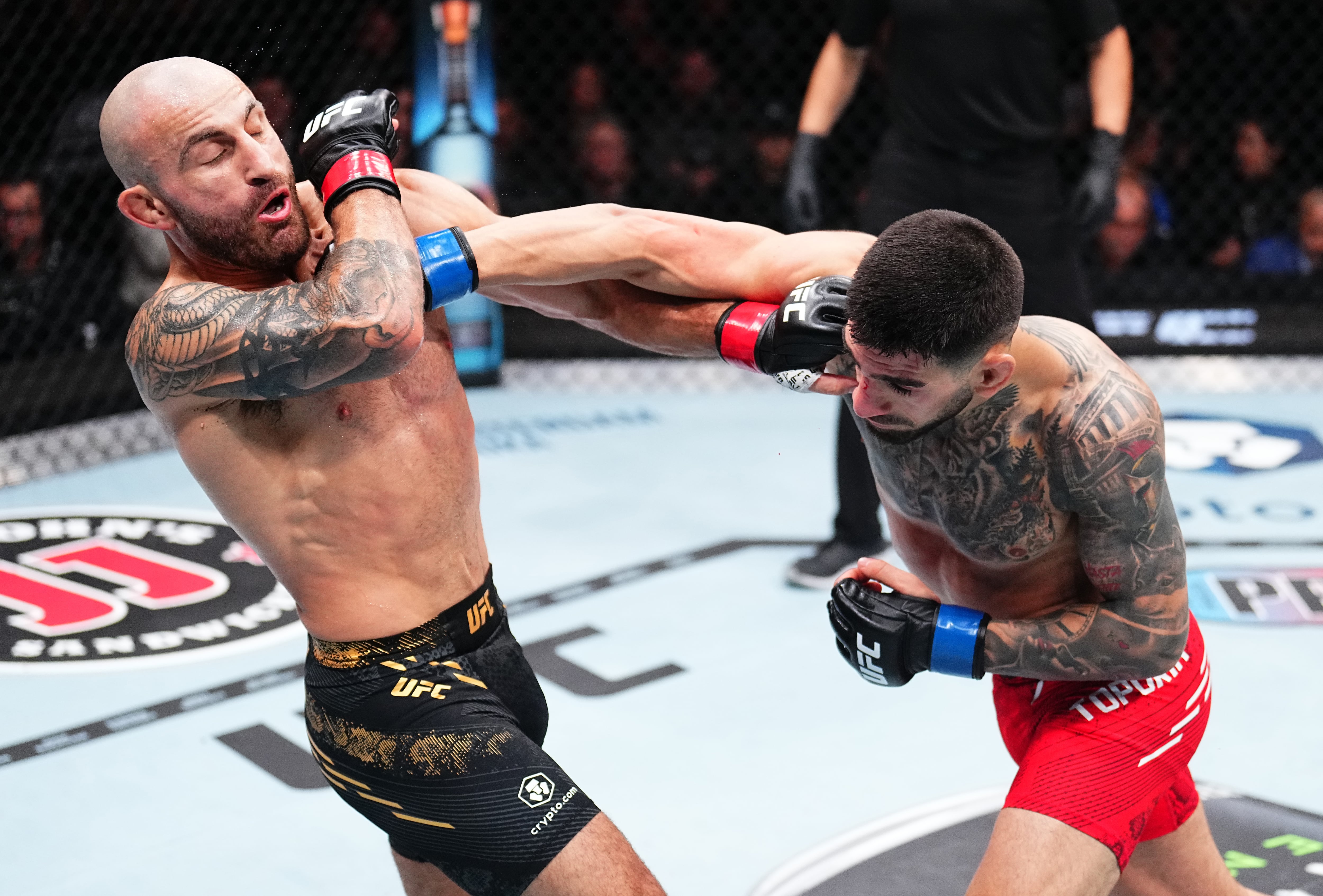 Ilia Topuria engancha un puñetazo en la cara de Alexander Volkanovski en la pelea por la lucha del cinturón de peso pluma. (Photo by Chris Unger/Zuffa LLC via Getty Images)