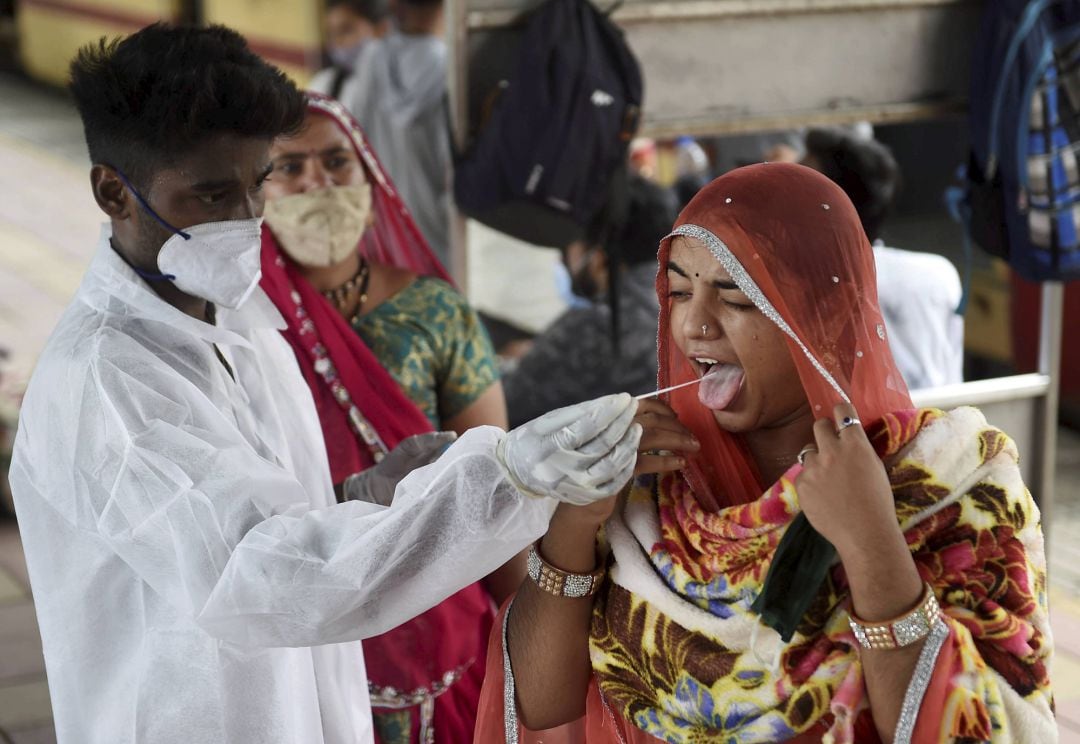 Un sanitario realiza un test contra el COVID-19 en una estación de trenes en Mumbai