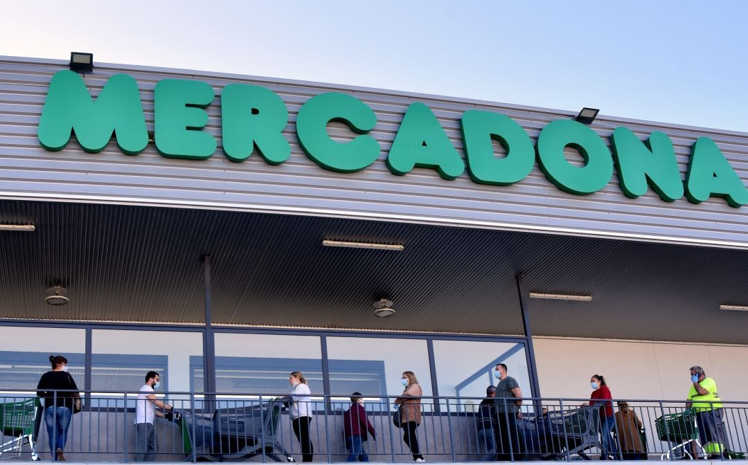 Varios clientes de Mercadona hacen cola para comprar.